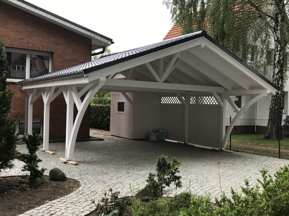 Satteldach Doppelcarport AlpineXL in Weiß mit eleganten Bögen und massiven Pfosten. Die Bretterschalung und das Vivaldi-Dach in Ziegeloptik unterstreichen handwerkliche Präzision.