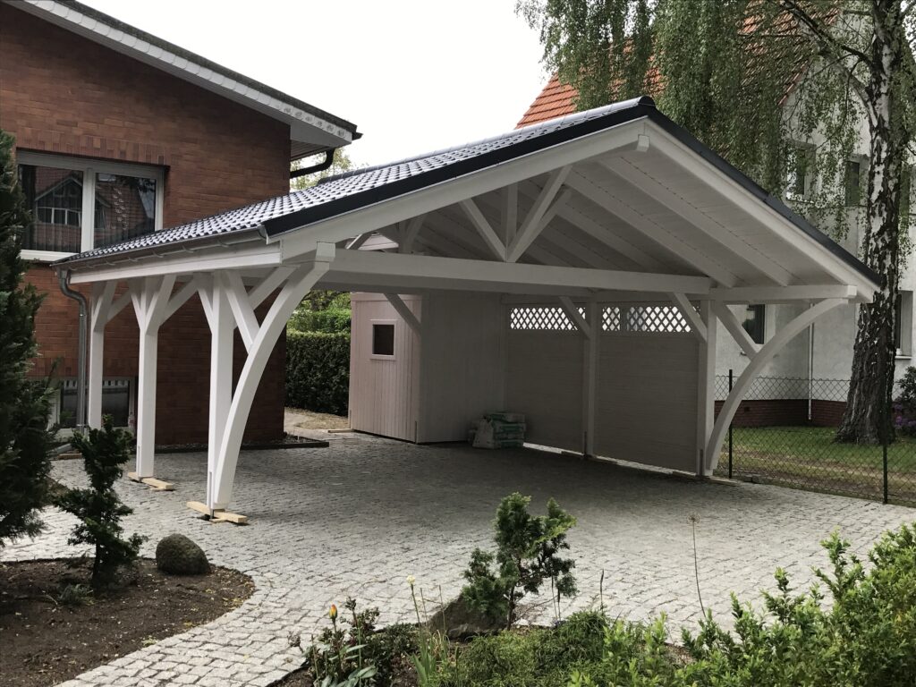 Satteldach Doppelcarport AlpineXL in Weiß mit eleganten Bögen und massiven Pfosten. Die Bretterschalung und das Vivaldi-Dach in Ziegeloptik unterstreichen handwerkliche Präzision.