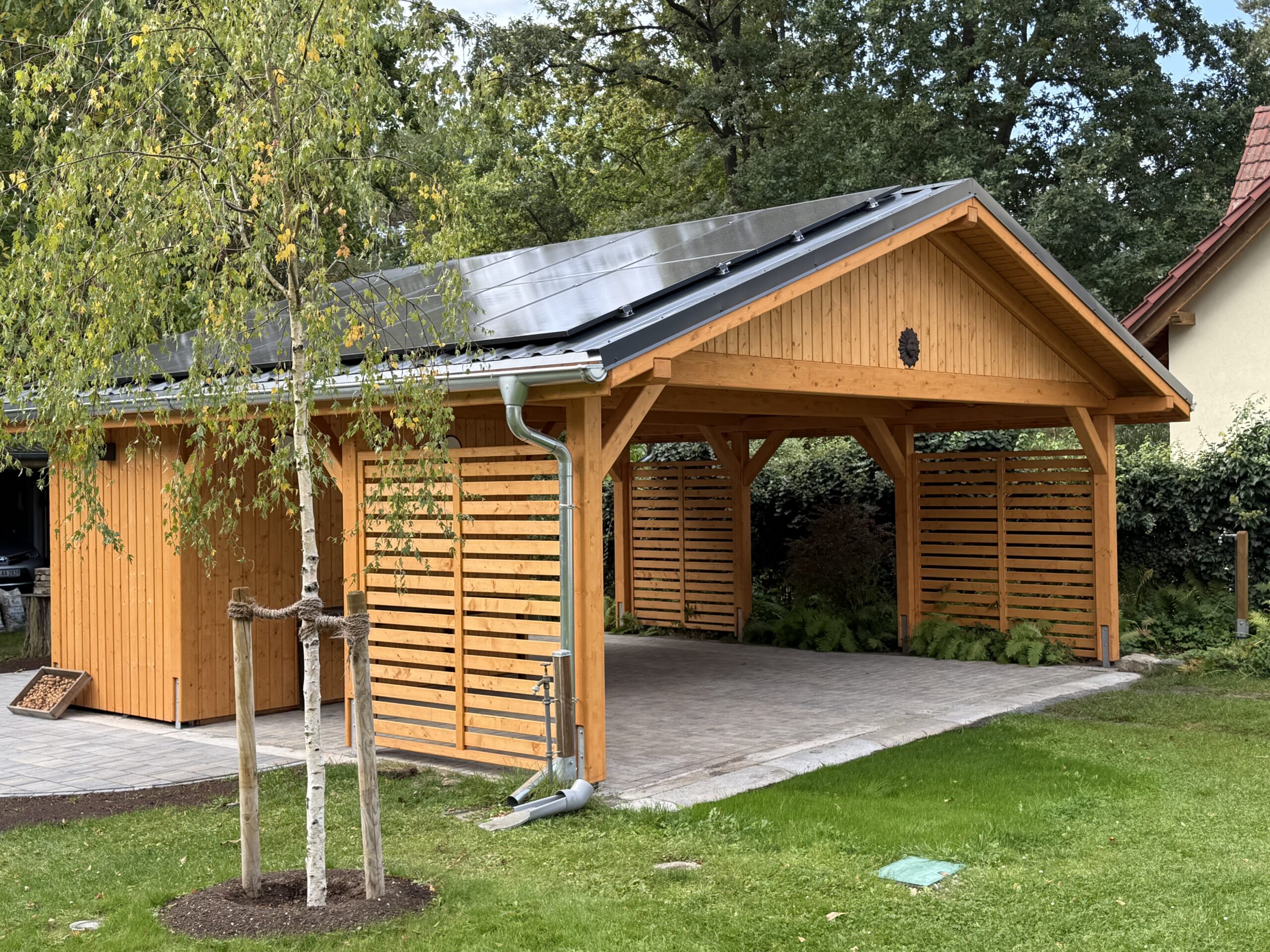 Satteldach Carport aus Holz mit Naturholzmaserung, vorbereitet für Photovoltaik. Eine warme, offene Konstruktion – ideal als Carport und Treffpunkt für Familie und Freunde.