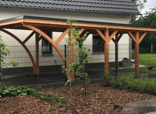Carport mit Flachdach und stabiler Holzstruktur, gefertigt aus imprägniertem Holz. Die Konstruktion zeigt präzise Verarbeitung und solide Handwerksausführung.