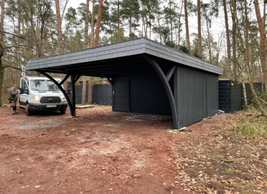 Carport DarkElegance mit geschlossener Seitenwand bis unter das Dach, dunkelgrün imprägniert. Solide Holzverarbeitung und klare Linien in perfekter Balance.