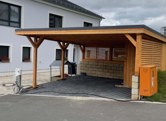 Moderner Carport mit Flachdach, Holz imprägniert, solide Bauweise mit großen Pfosten. Die klare Frontgestaltung betont Stabilität und handwerkliche Präzision.