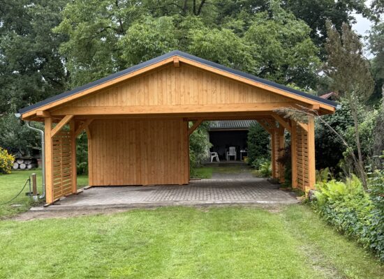 Frontansicht des Holzcarports mit vertikaler Giebelverkleidung und eleganten Linien. Satteldach, Naturholzmaserung und perfekte Proportionen.