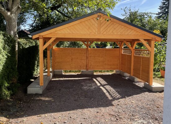 LandhausStyle Carport mit Satteldach und seitlichen Wänden, massiv und zugleich elegant. Die Proportionen und der Giebel verleihen dem Bauwerk eine majestätische Anmutung.