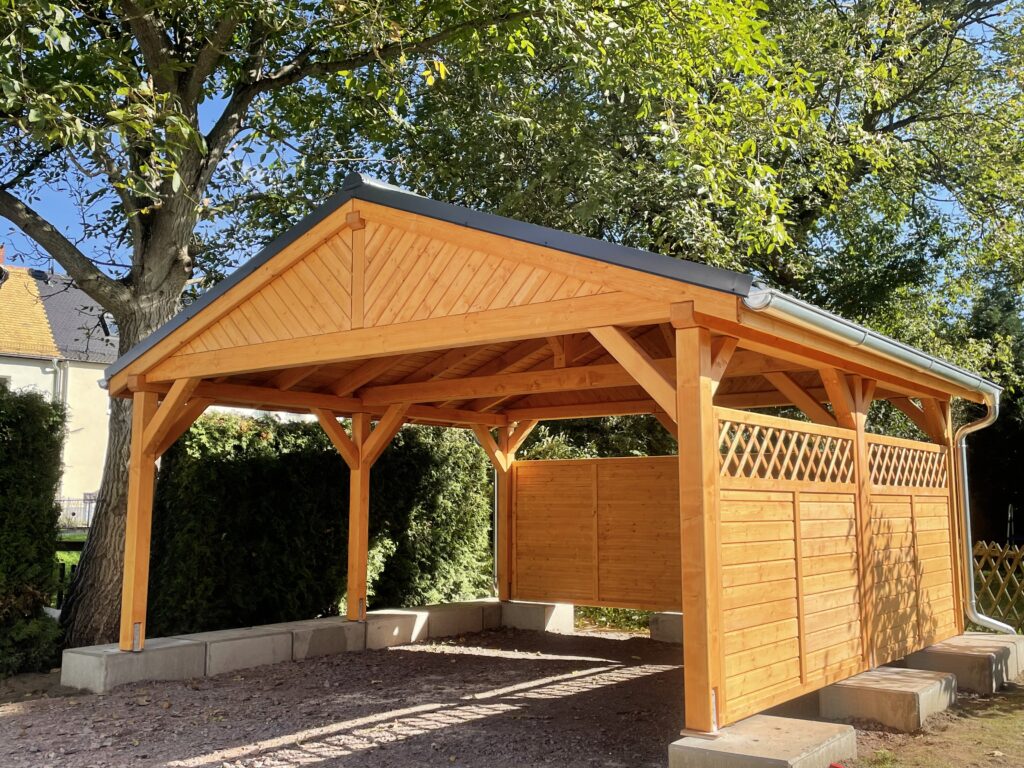 Satteldach Doppelcarport LandhausStyle mit klassischer Giebelverkleidung aus schrägen Brettern. Die harmonische Front betont handwerkliche Qualität und zeitlose Form.