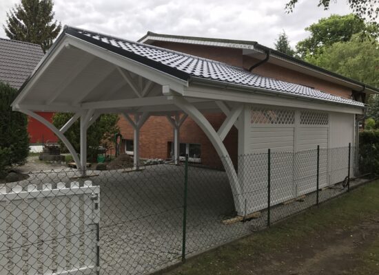 Seitenansicht des Carports mit Zaunelementen im Landhausstil. Die Anlage fügt sich harmonisch in das Grundstück und die Umgebung ein.