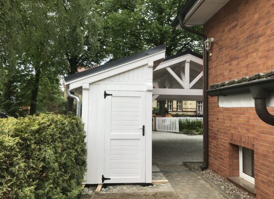 Anbauschuppen des AlpineXL Carports, funktional integriert und weiß gestrichen. Klare Proportionen, stabile Türen und perfekte Passgenauigkeit.