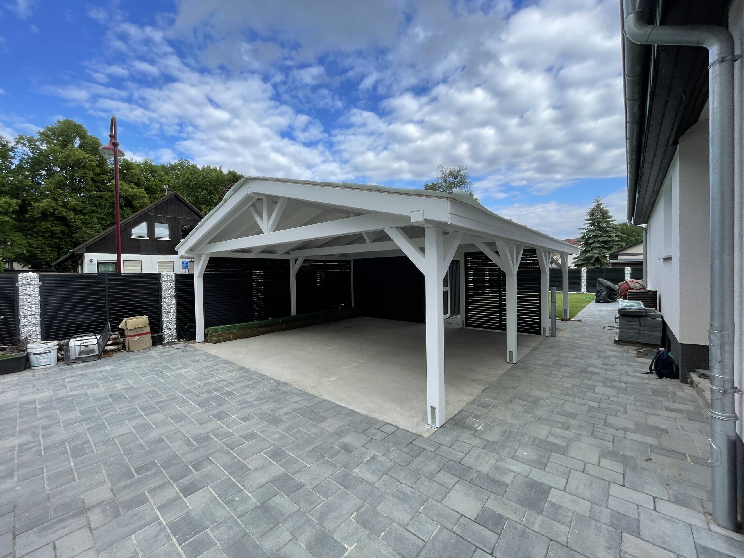 Carport Classic&Modern mit Satteldach, stilvoll in die Gartenlandschaft integriert. Weiß und Anthrazit wirken dezent und gleichzeitig hochwertig.