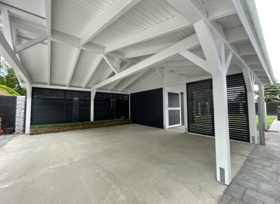 Innenansicht des Carports mit sichtbarer Dachkonstruktion und Bretterschalung. Die präzise Ausführung der Holzdetails steht für echtes Handwerk.