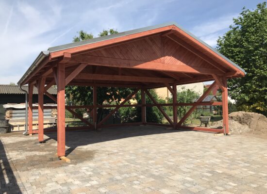 Heritage Carport mit Satteldach und sichtbarer Holzstruktur, imprägniert und handwerklich gefertigt. Klare Linien, stabile Form und warmer Farbton.