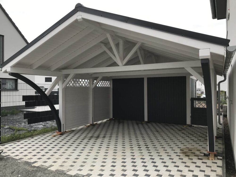 Satteldach Doppelcarport Vivaldi in Weiß mit anthrazitfarbenen Bögen und Blende. Die klare Linienführung und der Farbkontrast verleihen der Konstruktion Eleganz und Ausdruck.