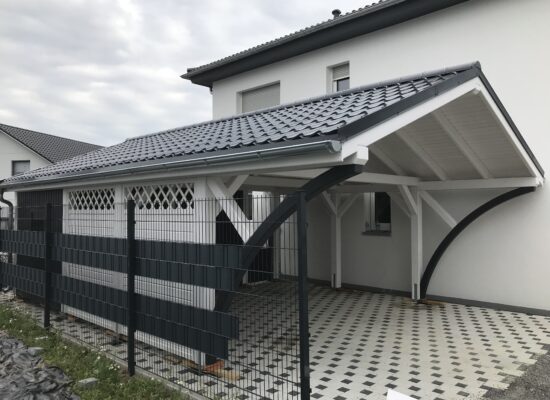 Seitenansicht mit Zaunelement und Vivaldi-Blech in Dachziegeloptik. Die Kombination aus Funktionalität und klassischem Design schafft ein stimmiges Gesamtbild.