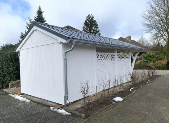 Country Carport mit geschlossener Rückwand und klarer Holzstruktur. Klassisches Satteldachdesign mit liebevoll ausgeführten Details.