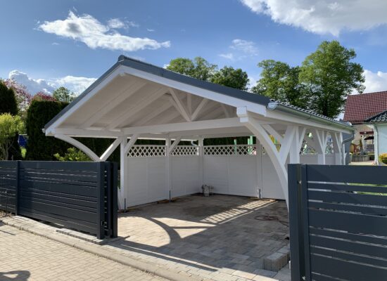 Premium Doppelcarport Weiß mit anthrazitfarbenem Vivaldi-Dach und weißen Rundbögen. Die massive Holzstruktur und harmonische Farbgestaltung fügen sich perfekt ins Grundstück ein.