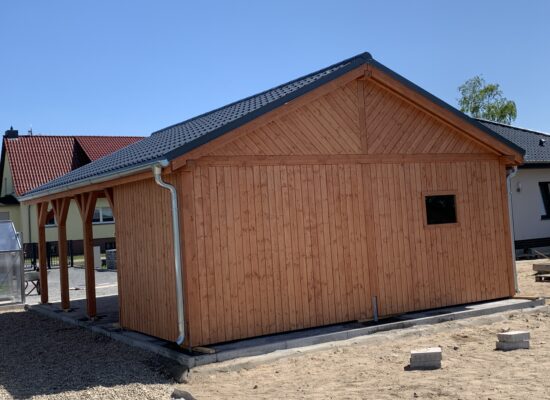 Rückansicht des Country Carports mit großflächiger Holzrückwand und kleinem Fenster 60x80. Die Dimensionen betonen Stabilität und handwerkliche Ausführung.
