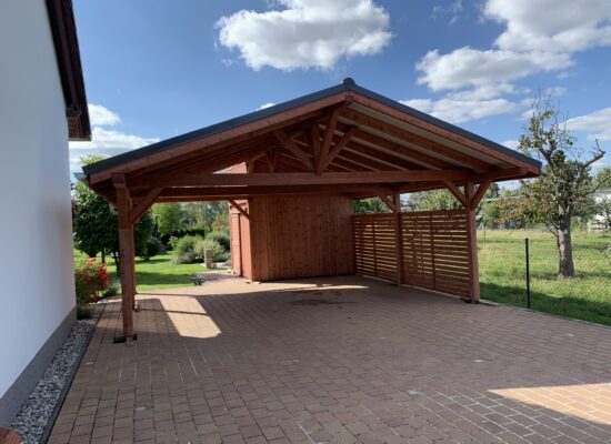 Frontansicht des NaturaLine Doppelcarports mit Satteldach, Lamellenwand und Naturholzoptik. Die massive Struktur wirkt offen und einladend zugleich.