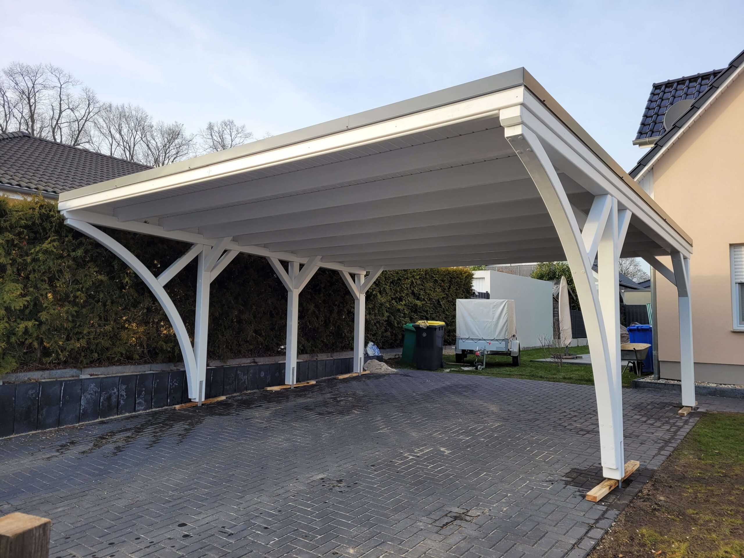 Klassischer Doppelcarport in Weiß mit Rundbögen und massiven 14 × 14 cm Pfosten. Die saubere Dachverkleidung verleiht dem Carport ein elegantes, harmonisches Gesamtbild.