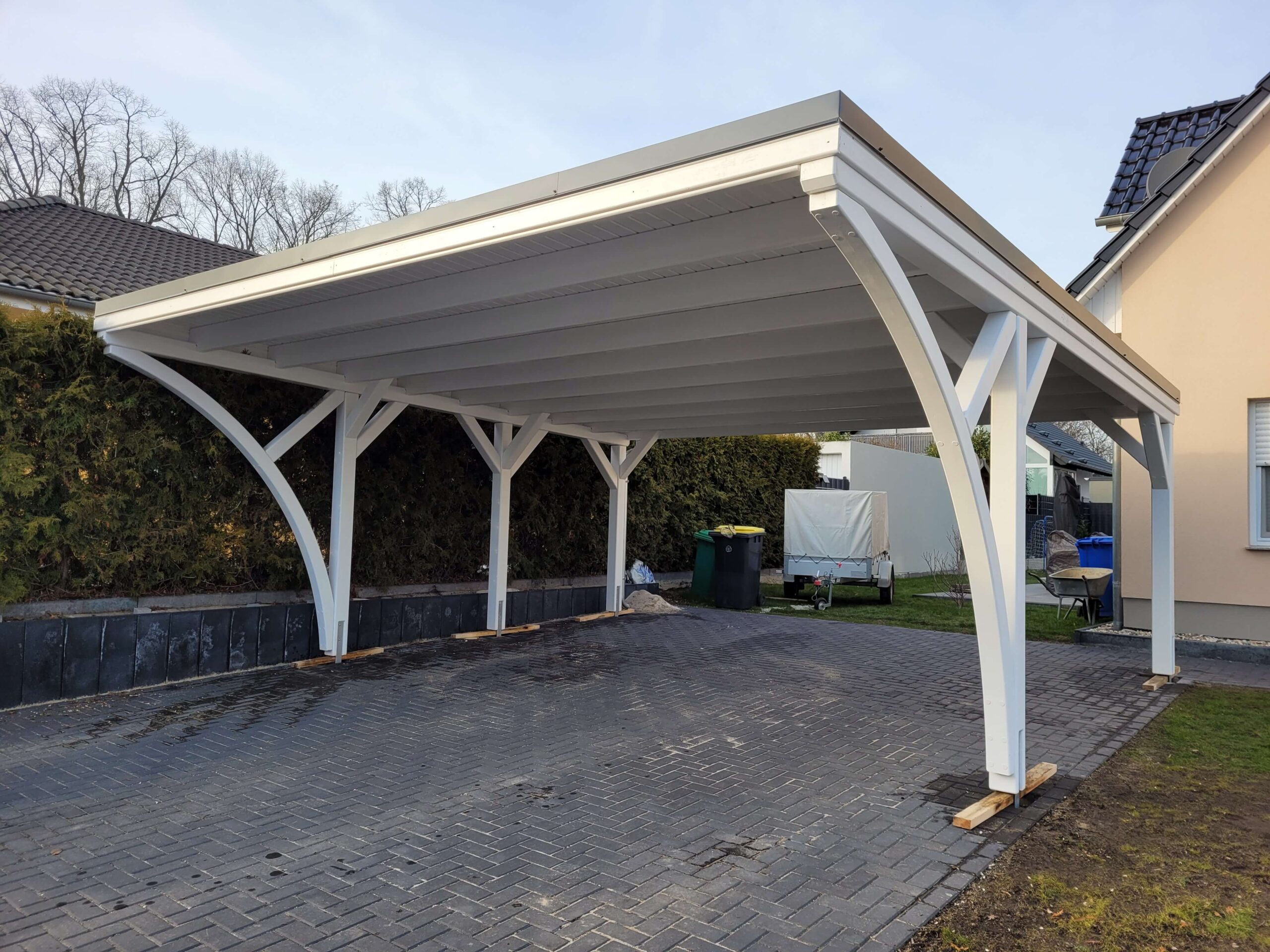 Klassischer Doppelcarport in Weiß mit Rundbögen und massiven 14 × 14 cm Pfosten. Die saubere Dachverkleidung verleiht dem Carport ein elegantes, harmonisches Gesamtbild.