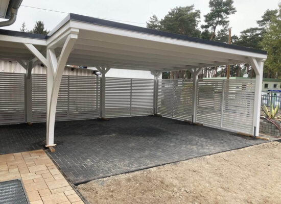 Carport Plus mit klassischer Blende und weißer Holzstruktur, modern und klar gestaltet. Die Kombination aus Stabilität und Leichtigkeit verleiht der Anlage zeitlose Eleganz.