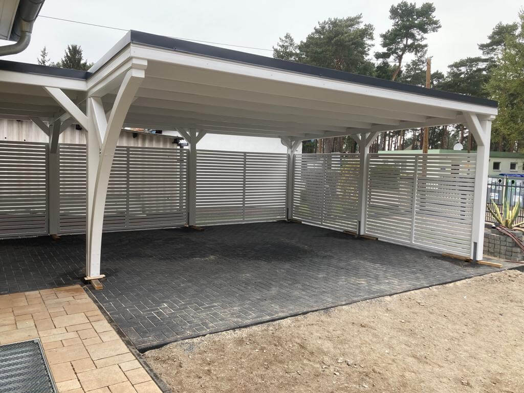 Carport Plus mit klassischer Blende und weißer Holzstruktur, modern und klar gestaltet. Die Kombination aus Stabilität und Leichtigkeit verleiht der Anlage zeitlose Eleganz.