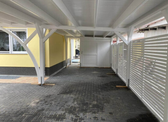 Innenansicht des Carport Plus mit Bretterschalung und integrierter Schuppenwand. Die klare Holzstruktur und präzise Verarbeitung zeigen die handwerkliche Qualität im Detail.