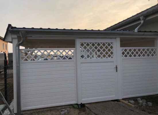 Rückansicht des weißen Doppelcarports mit geschlossener Rückwand und klarer Holzstruktur. Die massive Bauweise und harmonische Farbgestaltung stehen für Qualität.