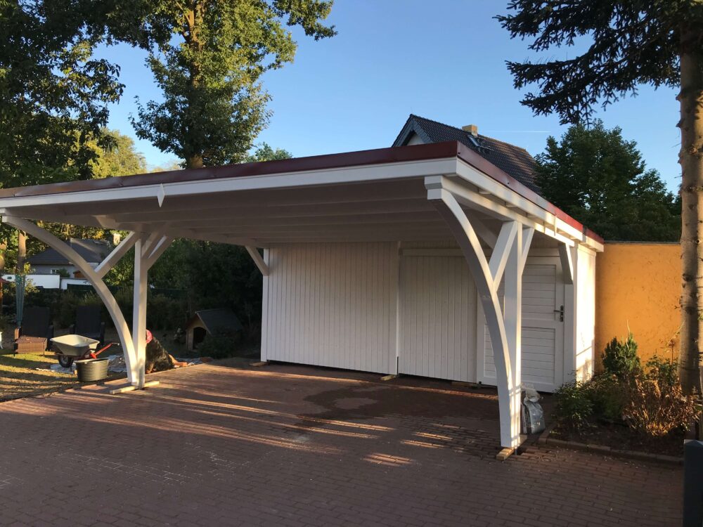 Flachdach-Carport RoyalLine mit großzügigem Geräteraum und harmonischem Farbspiel Weiß-Bordo. Die Frontansicht zeigt Stabilität, Präzision und ästhetische Ausgewogenheit.