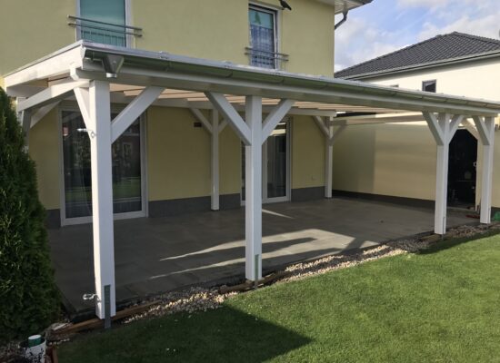 Terrassenüberdachung aus Holz mit brauner Doppelstegplatte und markanten Pfosten. Die klare Linienführung und harmonische Farbwirkung schaffen Ruhe und Eleganz.