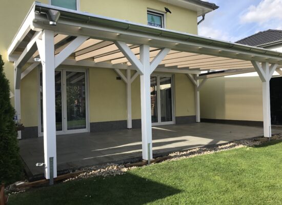 Nahaufnahme der 14-cm-Pfosten und der weißen Holzkonstruktion unter dem braunen Doppelstegdach. Die solide Ausführung steht für Langlebigkeit und Stil.