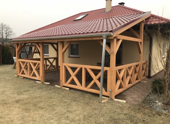 Seitenansicht der Terrassenüberdachung mit Vivaldi-Blechdach und Kreuzgeländer. Handwerkliche Details und klare Linienführung betonen die Qualität.