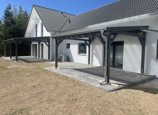 Zwillings-Terrassenüberdachungen in Anthrazit, harmonisch nebeneinander platziert. Klare Linien und moderne Holzbauweise in perfekter Symmetrie.