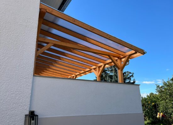 Terrassenüberdachung oberhalb der Garageneinfahrt – stabile Konstruktion mit sicherem Fundament und perfektem Anschluss ans Gebäude.